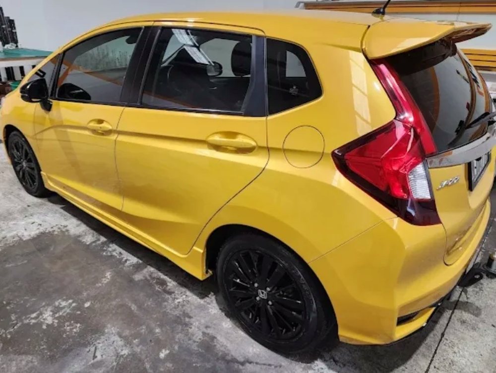 Yellow Honda Jazz with dark carbon window tint
