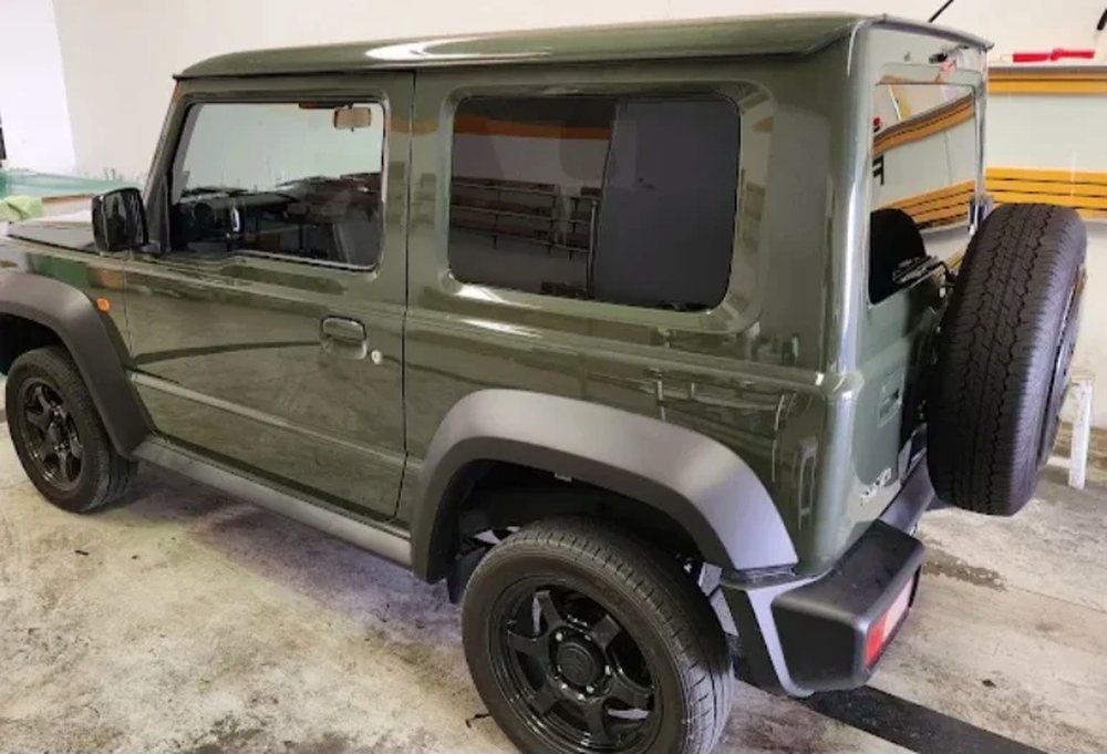 Green Suzuki Jimny with dark tinted windows